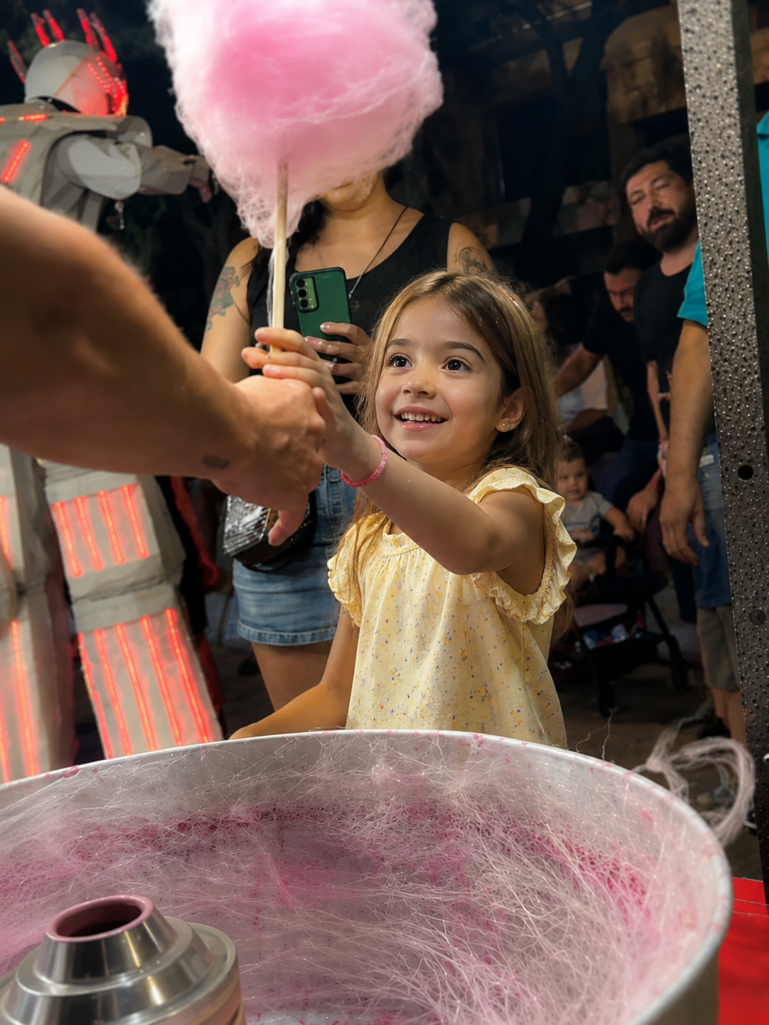 Una niña recibiendo algodón de azúcar en un evento
